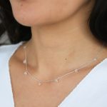 het model draagt een edelsteen ketting. Gemaakt van echt zilveren ketting, waaraan witte topaas edelstenen hangen.