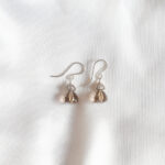 korte zilveren oorbellen met kleine grijsbruine rookkwarts in pyramide vorm. Rondom facet geslepen, zeer helder.